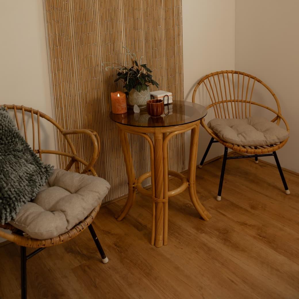 Wachtruimte van Touch of Harmony met twee rotan stoelen, glazen tafeltje en kaars.