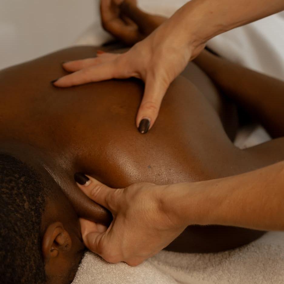 Close‑up schoudermassage: Joy geeft diepe druk langs nek en schouderblad